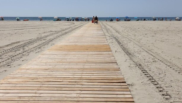 A wooden pier leading to a beach with people in the distance. - Holidays in Tamarit beach  (Santa Pola)