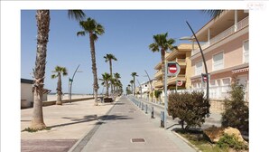 A coastal promenade with palm trees, a bike lane, and beachfront buildings. - Holidays in Tamarit beach  (Santa Pola)