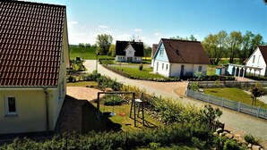 Ett bostadsområde med hus, en gunga och en asfalterad väg.
