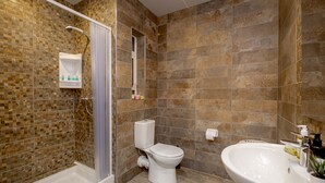 Ein Badezimmer mit Dusche, Toilette und Waschbecken.