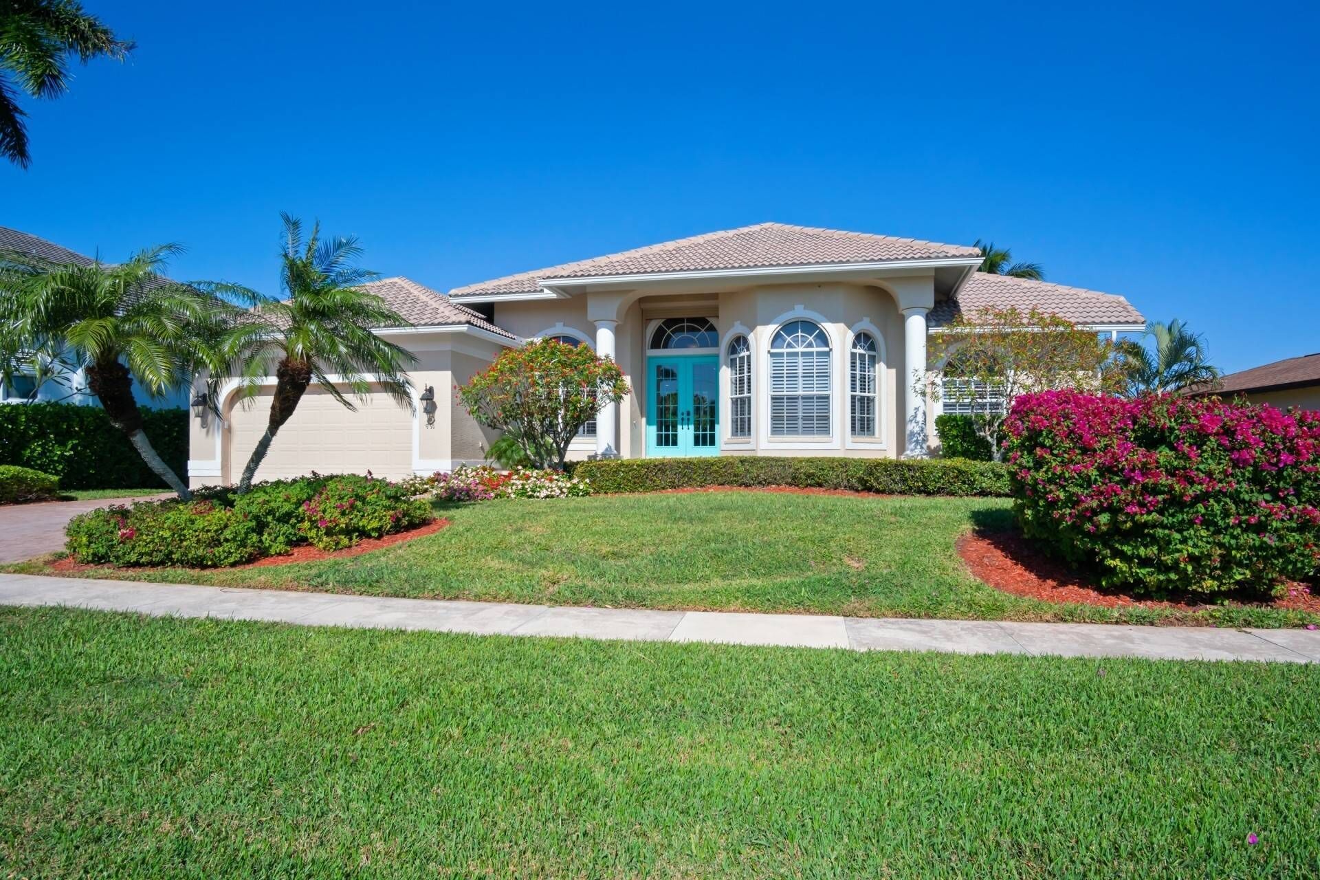 A two-story house with a blue door, white columns, and a tiled roof.