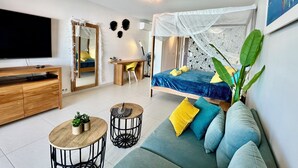 A modern bedroom with a bed, bedside table, and a TV. - Studio in the heart of Saint François on the Marina (Saint francois)