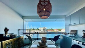 A modern kitchen with a view of a marina, a washing machine, and a dining area with a view. - Studio in the heart of Saint François on the Marina (Saint francois)