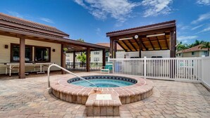 A circular hot tub with a tiled edge, surrounded by a paved patio area with hexagonal tiles. - Beautiful Florida Condo near beach in Bradenton (Bradenton)