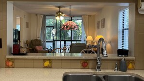 A kitchen with a dishwasher, a sink, and a window with curtains. - Beautiful Florida Condo near beach in Bradenton (Bradenton)