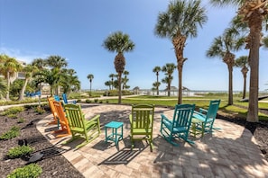 A patio area with outdoor seating and palm trees. - Horizons West #701 - Incomparable View - Siesta Key / Crescent Beach (Sarasota)