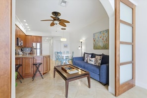 A living room with a sofa, coffee table, and a ceiling fan. - Horizons West Unit #112 - A "Getaway with a Gulf View" (Sarasota)