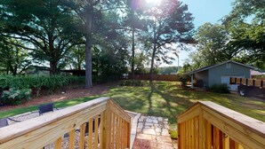 A backyard with a wooden deck, stone pathway, and a small shed. - Convenient to everything!! (Cartersville)