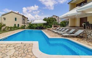 Relax by the pool surrounded by lounge chairs and umbrellas.