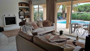 A modern living room with a sofa, a floor lamp, and a TV.
