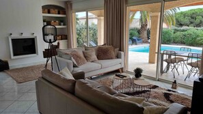 A modern living room with a sofa, a floor lamp, and a TV. - Beautiful Villa ★★★★, air-conditioned, private pool, 4 bedrooms, close beaches. (Fréjus)