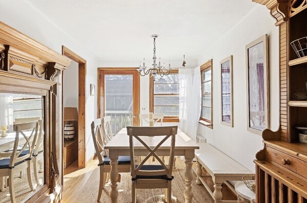Enjoy meals in this dining area with a central table and comfortable seating, surrounded by cabinets and shelves.