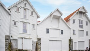 A row of white wooden houses with gabled roofs and stone foundations. - Nice home in Sandve with house sea view (Sandve)