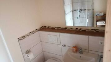 A small bathroom with a toilet, sink, and mirror.