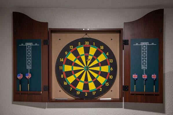 A dartboard with a bullseye and numbered rings, flanked by two dartboards with flags and numbers.