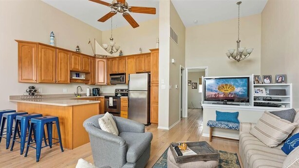 A modern kitchen with wooden cabinets, a central island, and blue bar stools.