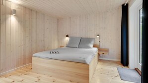 A wooden-paneled bedroom with a bed, two bedside lamps, and a window with curtains.