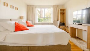 A bedroom with a large bed, a TV, and a window with curtains. - 60 m2 luxury apartment with double jacuzzi and private Finnish sauna, in villa (Oss)