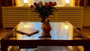A room with a glass-top coffee table, a vase with flowers, and a book. - 60 m2 luxury apartment with double jacuzzi and private Finnish sauna, in villa (Oss)