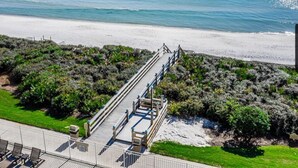 Un paseo marítimo que lleva a una playa con vista despejada al océano.