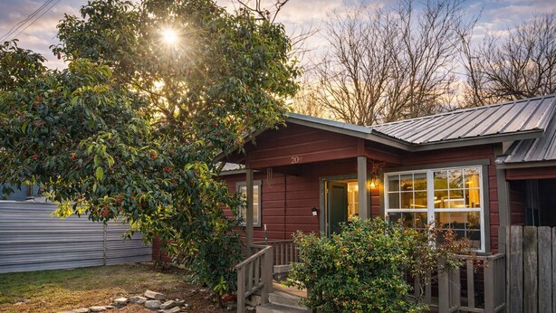 A red house with a metal roof, a front porch, and a stone pathway leading to the door. - South Congress Zen Den! Walk Everywhere! (Austin)