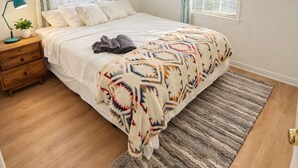 A bedroom with a bed, a nightstand, a lamp, and a window with curtains. - South Congress Zen Den! Walk Everywhere! (Austin)