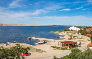 A coastal area with boats docked, a beach, and a white building with a red roof. - 3 bedroom gorgeous apartment in Kustici (Kustici)