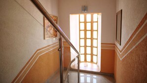 A staircase with a handrail leading to a door with a grid pattern.