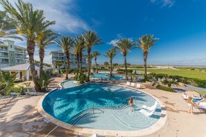 A resort pool area with multiple pools, palm trees, and lounge chairs. - YOU, ME, BY THE SEA - Spacious Bay-View Retreat at Pointe West (Galveston)