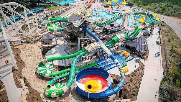 Een waterpark met een achtbaan, meerdere glijbanen en een zwembad.