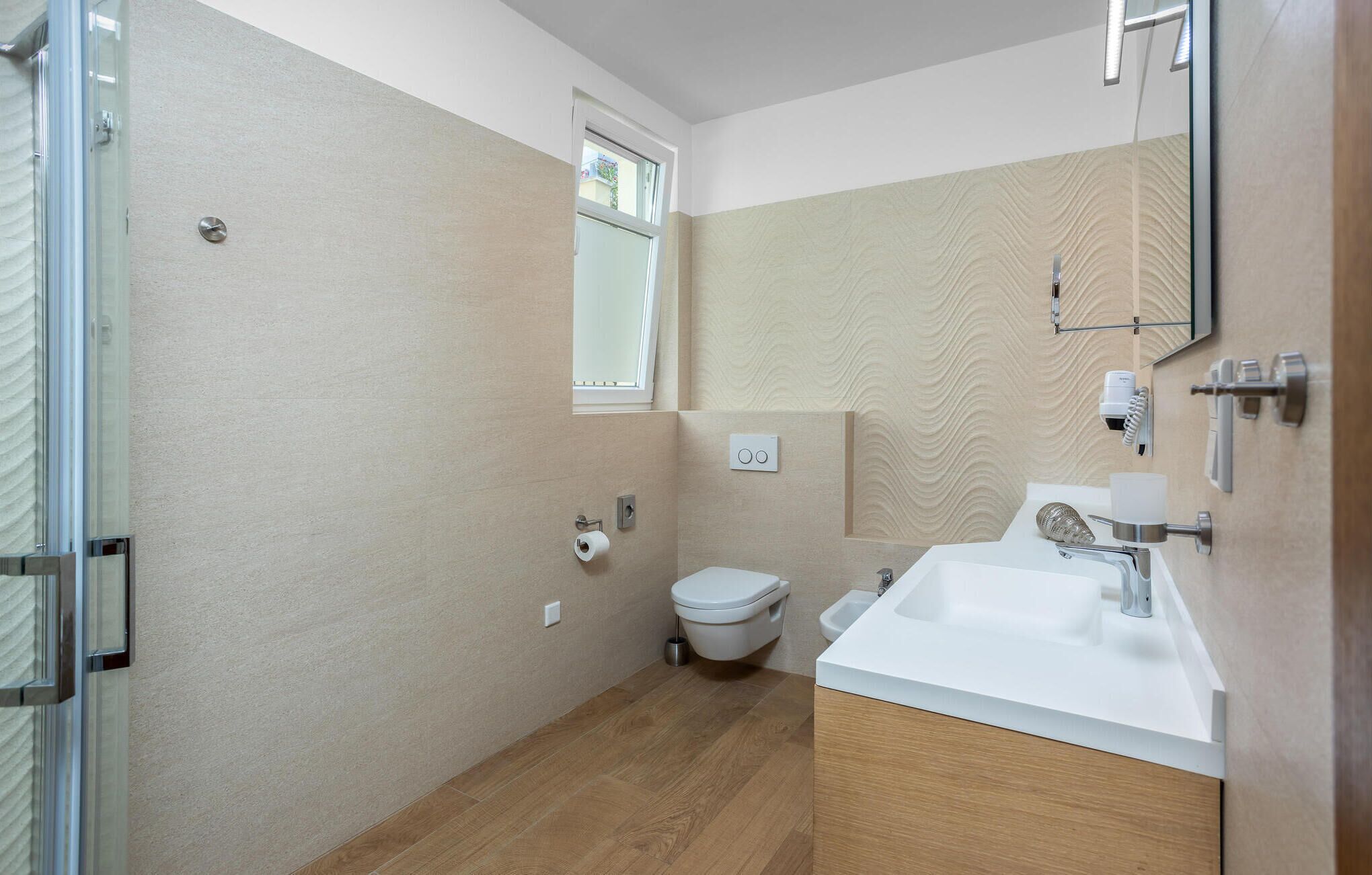 Une salle de bain moderne équipée de toilettes, d’un lavabo et d’une douche.