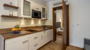 Una cocina moderna con encimeras de madera, un microondas integrado y un frutero.