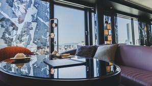 A modern interior with a round glass table, leather sofa, and large windows offering a city view. - Fauchon Hotel Kyoto (Kyoto)