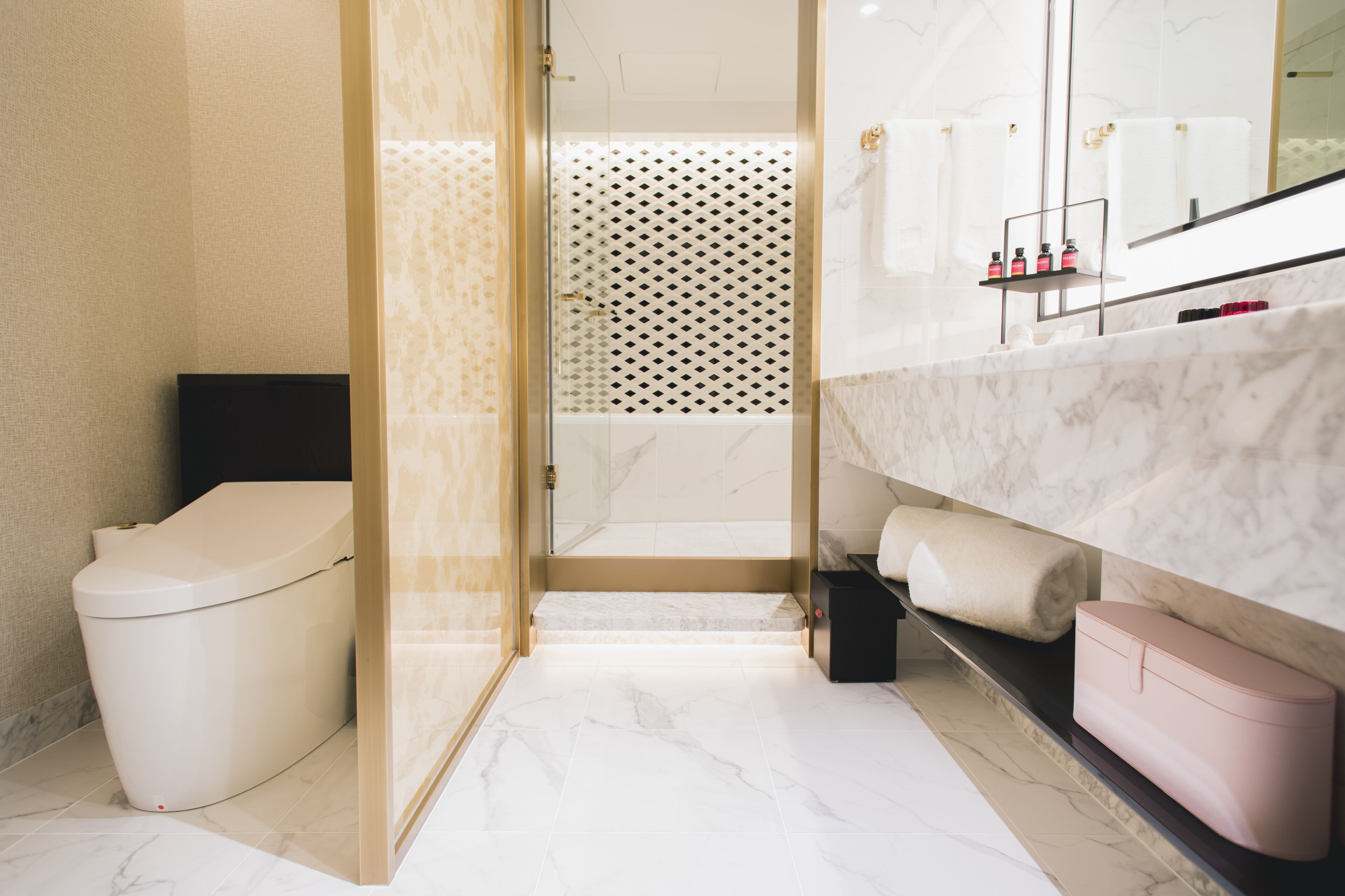 A modern bathroom with a toilet, shower, and sink area.