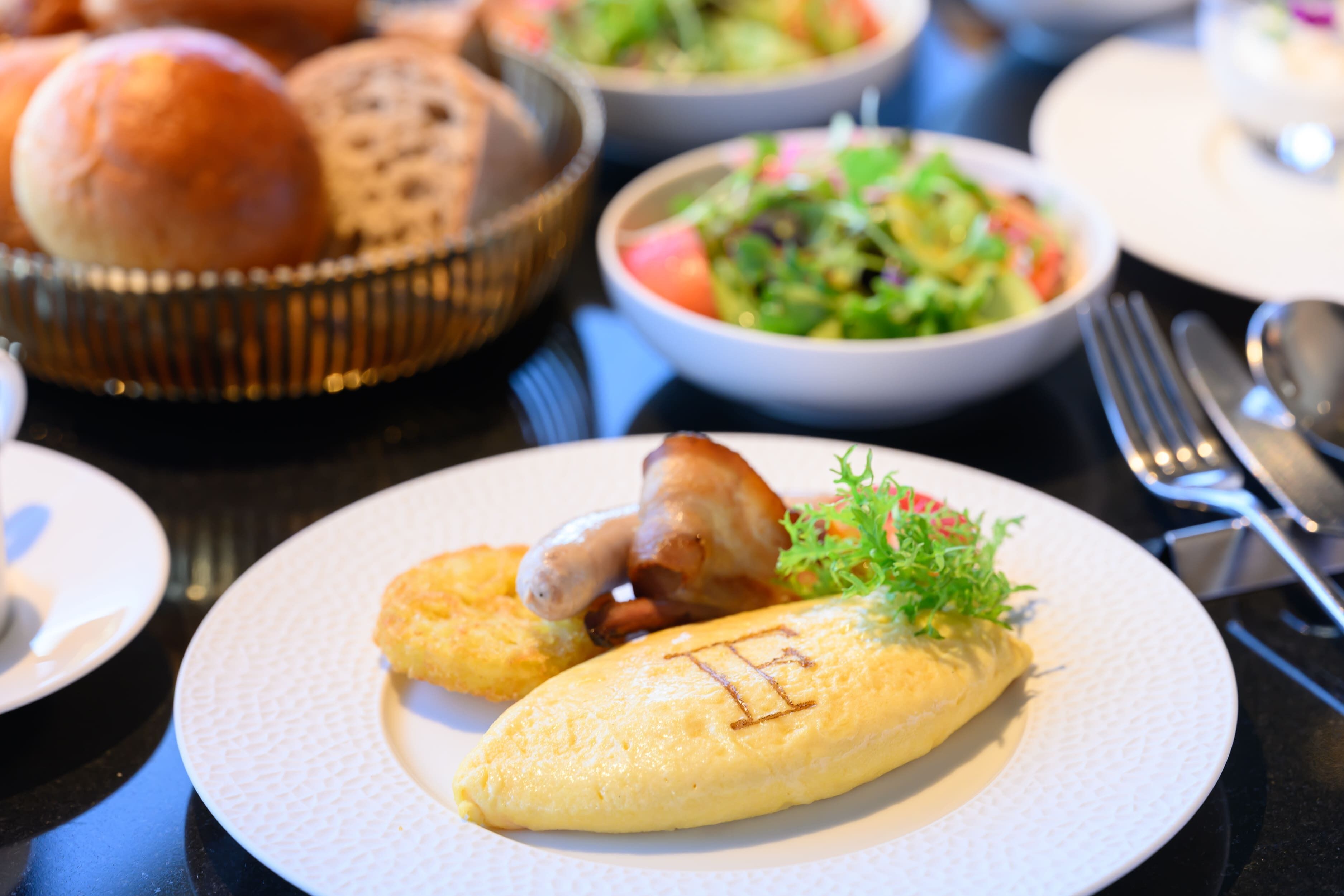 A dining table with various dishes including an omelette, salad, and bread.