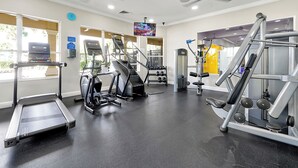 A gym with treadmills, elliptical machines, and weightlifting equipment. - SLEEP 17,6BR/4BADisney  Villa@WindsorHills,themed,Spa,Pool,GameRoom,5mi@Disney! (Kissimmee)