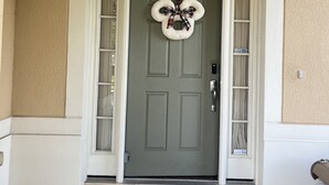 A front door with a wreath, a mailbox, and a doormat. - SLEEP 17,6BR/4BADisney  Villa@WindsorHills,themed,Spa,Pool,GameRoom,5mi@Disney! (Kissimmee)