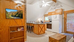 A kitchen with wooden cabinets, a white refrigerator, and a ceiling fan.