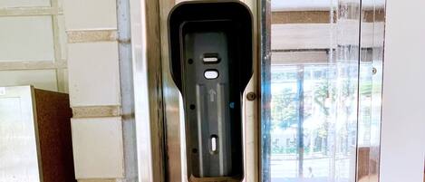 A close-up of a door with a keypad lock and a small window.