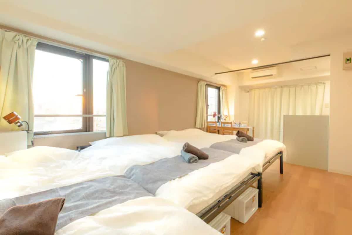 A hotel room with a large bed, a desk, and a chair.
