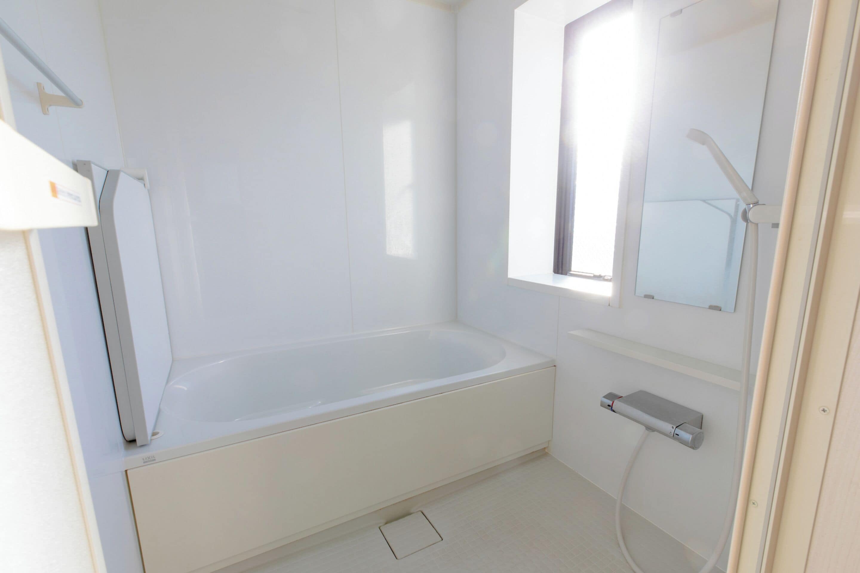 A modern bathroom with a bathtub, a toilet, and a shower.