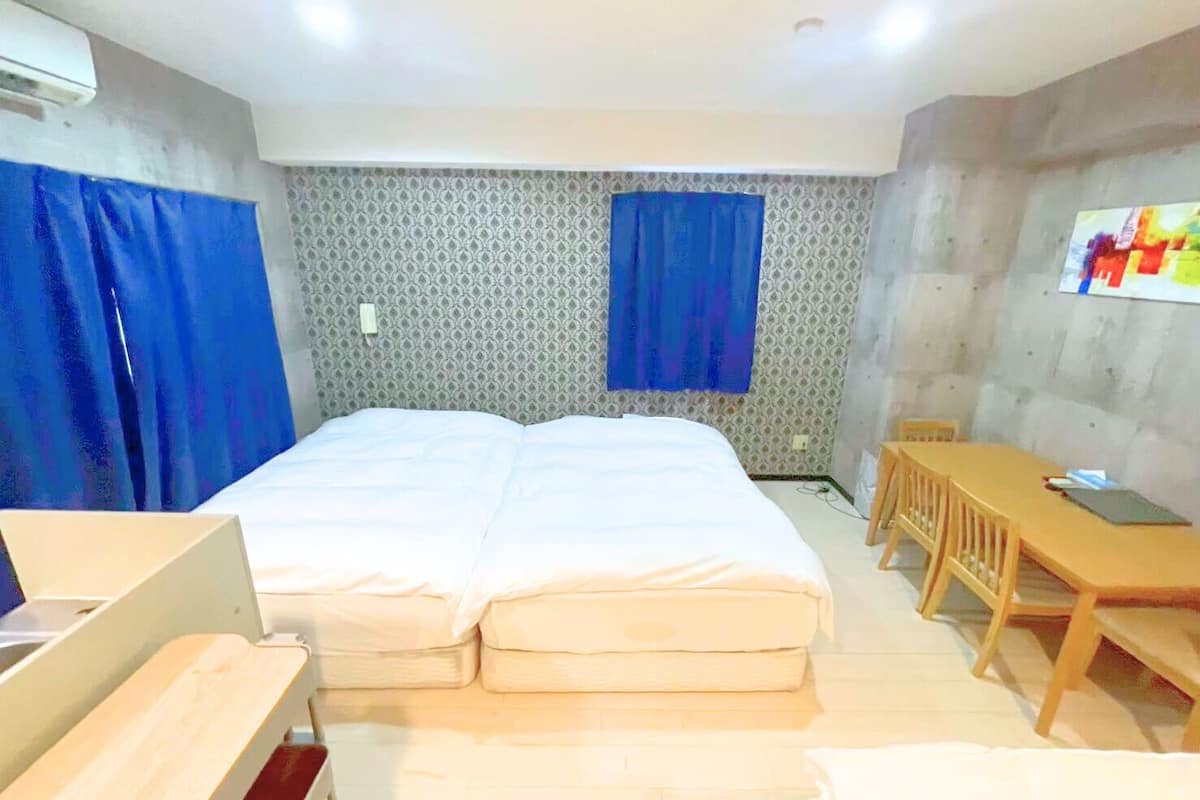 A hotel room with a large bed, a desk, and a TV.