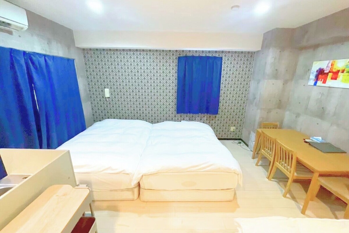 Une chambre d’hôtel avec un grand lit, un bureau et une chaise.