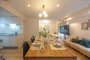 Een moderne woonkamer met een eethoek, een keuken en een televisie.