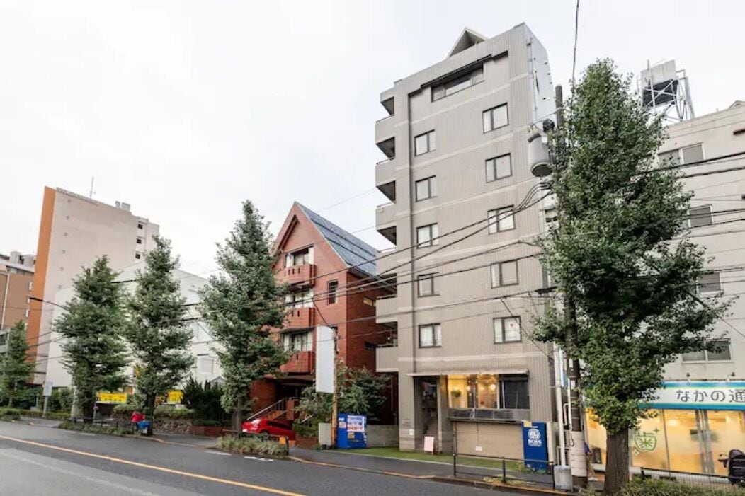 A multi-story building with a mix of residential and commercial spaces, including a restaurant with a visible sign.