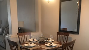 Uma área de jantar com uma mesa redonda de madeira, seis cadeiras e um candelabro.