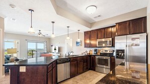 Una cocina moderna con armarios de madera oscura, electrodomésticos de acero inoxidable y una isla grande.