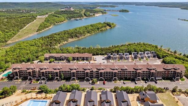 Ein mehrstöckiges Hotel mit Parkplatz und Seeblick.