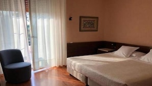 A hotel room with a bed, a chair, and a window with curtains. - Du Lac Hotel (Sirmione)