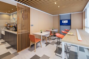 A modern hotel lobby with a bar area, seating arrangements, and a digital display. - Holiday Inn Express Foshan Chancheng (Foshan)